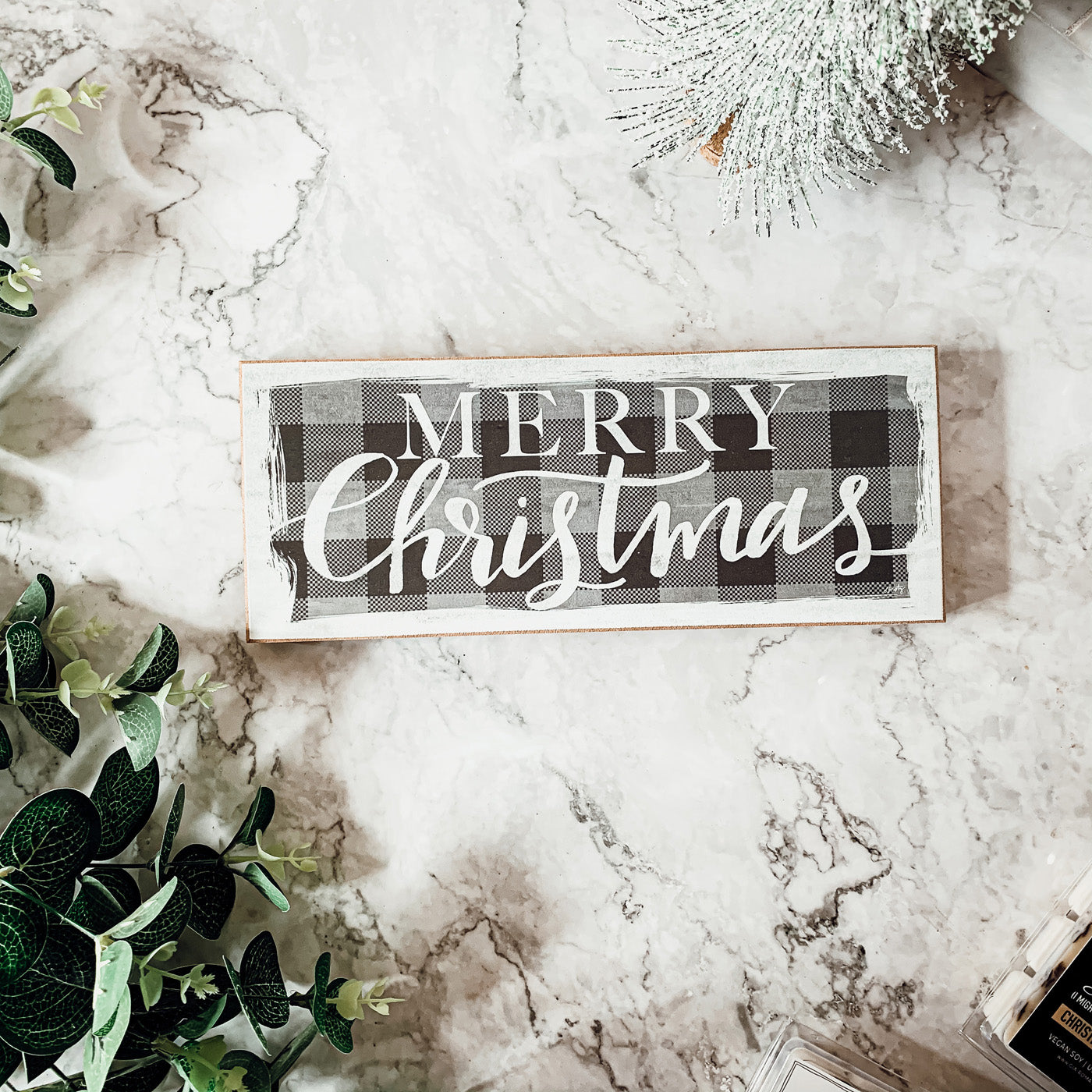 A handmade Buffalo Check Sign made of thick wood, featuring a classic black and white checkered pattern, perfect for holiday decor.