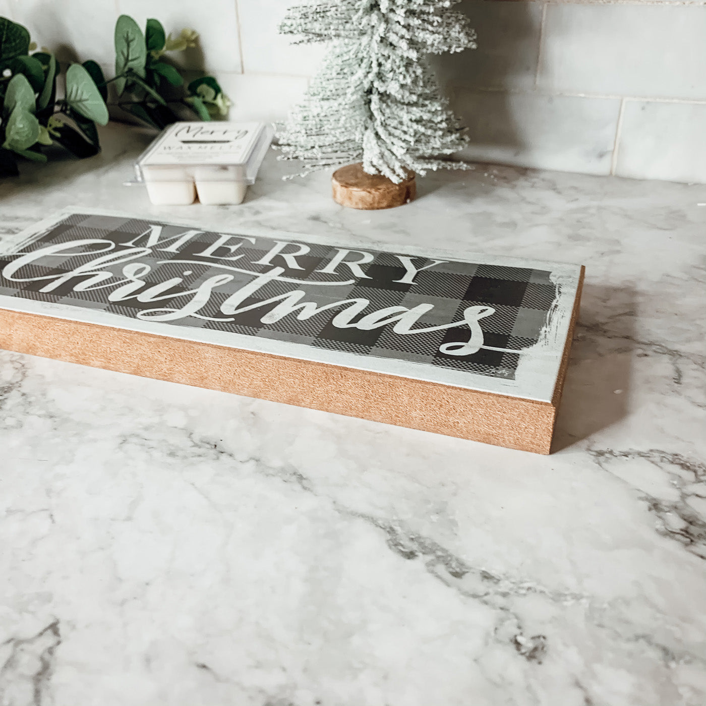 A handmade Buffalo Check Sign made of thick wood, featuring a classic black and white checkered pattern, perfect for holiday decor.