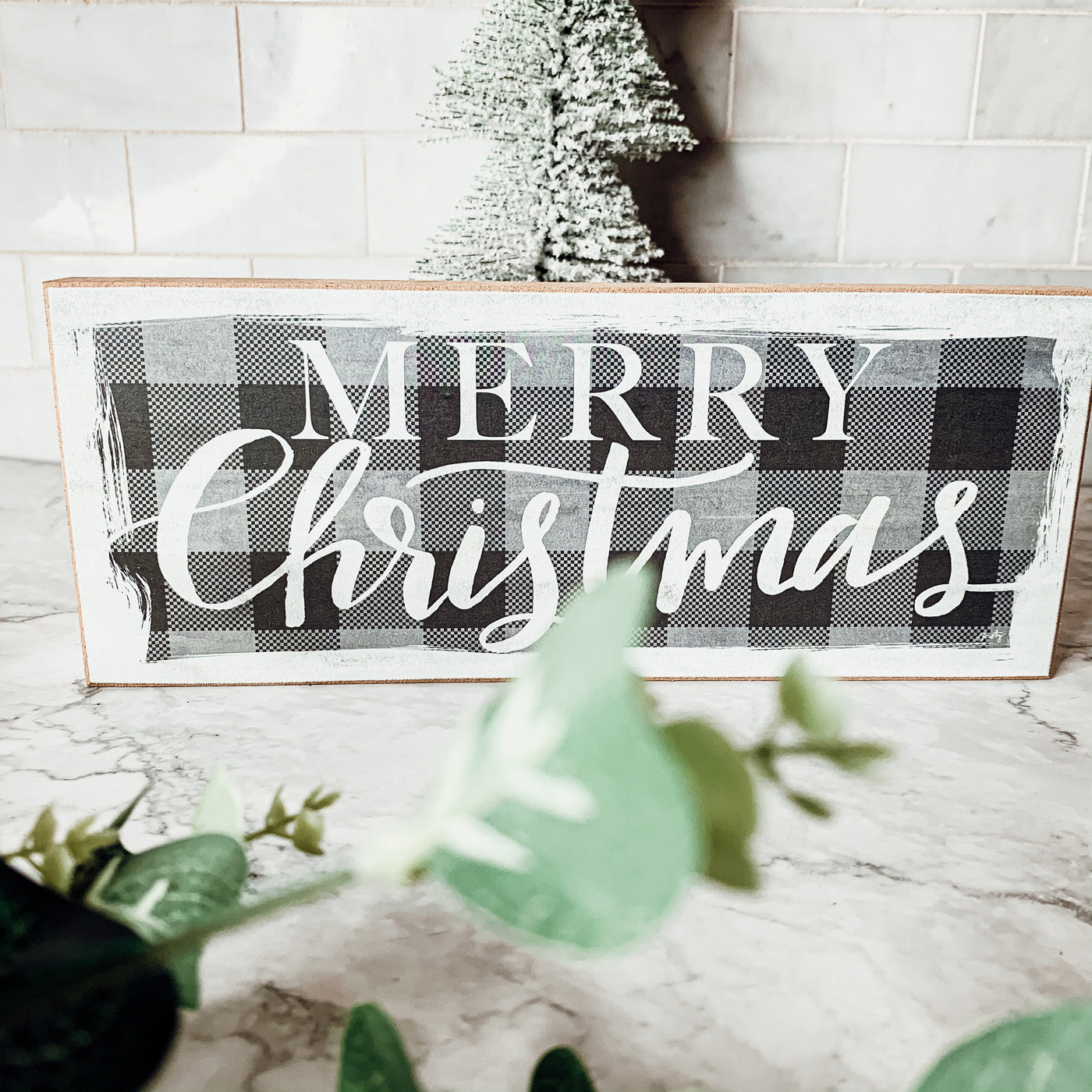 A handmade Buffalo Check Sign made of thick wood, featuring a classic black and white checkered pattern, perfect for holiday decor.