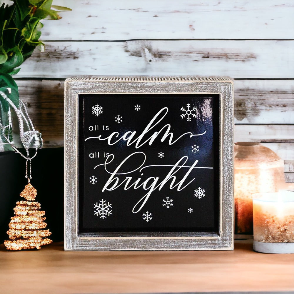 A stylish 7-inch wooden framed sign with embossed lettering that reads 'All is calm all is bright', perfect for holiday decor.