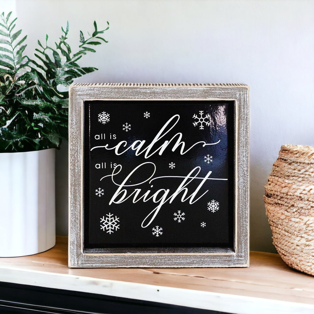 A stylish 7-inch wooden framed sign with embossed lettering that reads 'All is calm all is bright', perfect for holiday decor.