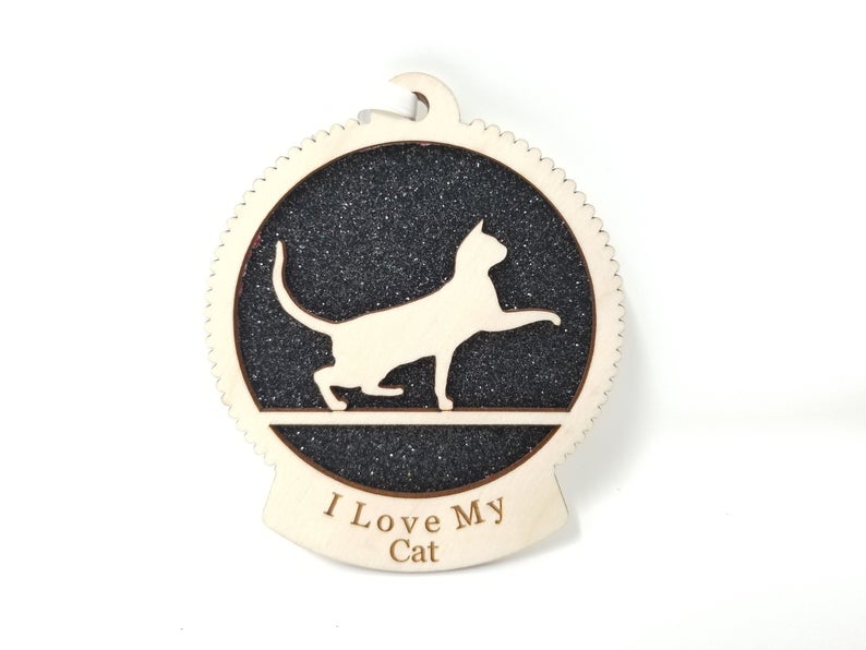 A beautifully crafted wooden ornament featuring a playful cat silhouette, perfect for Christmas decoration.