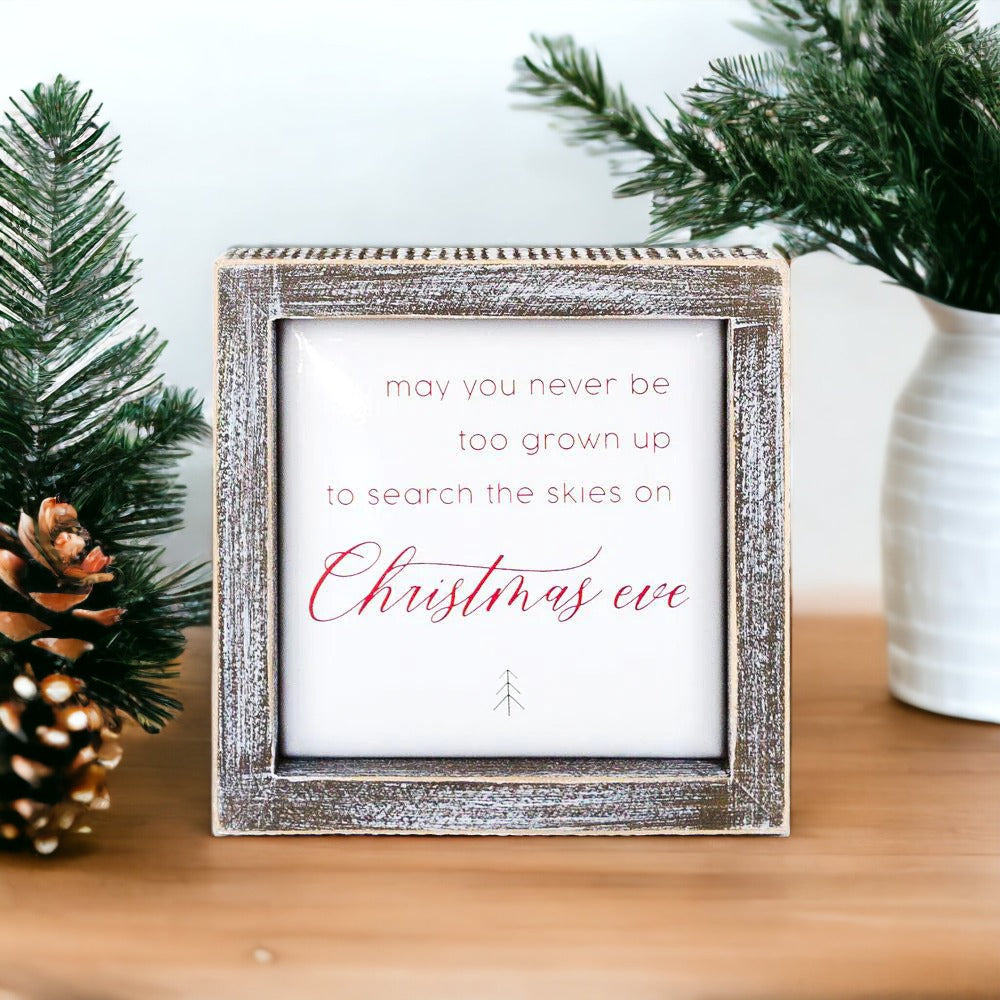 A beautifully crafted 5-inch wooden framed sign with metal embossed lettering that reads 'may you never be too grown to search the skies on Christmas eve'.