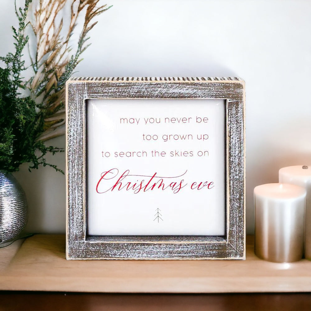 A beautifully crafted 5-inch wooden framed sign with metal embossed lettering that reads 'may you never be too grown to search the skies on Christmas eve'.