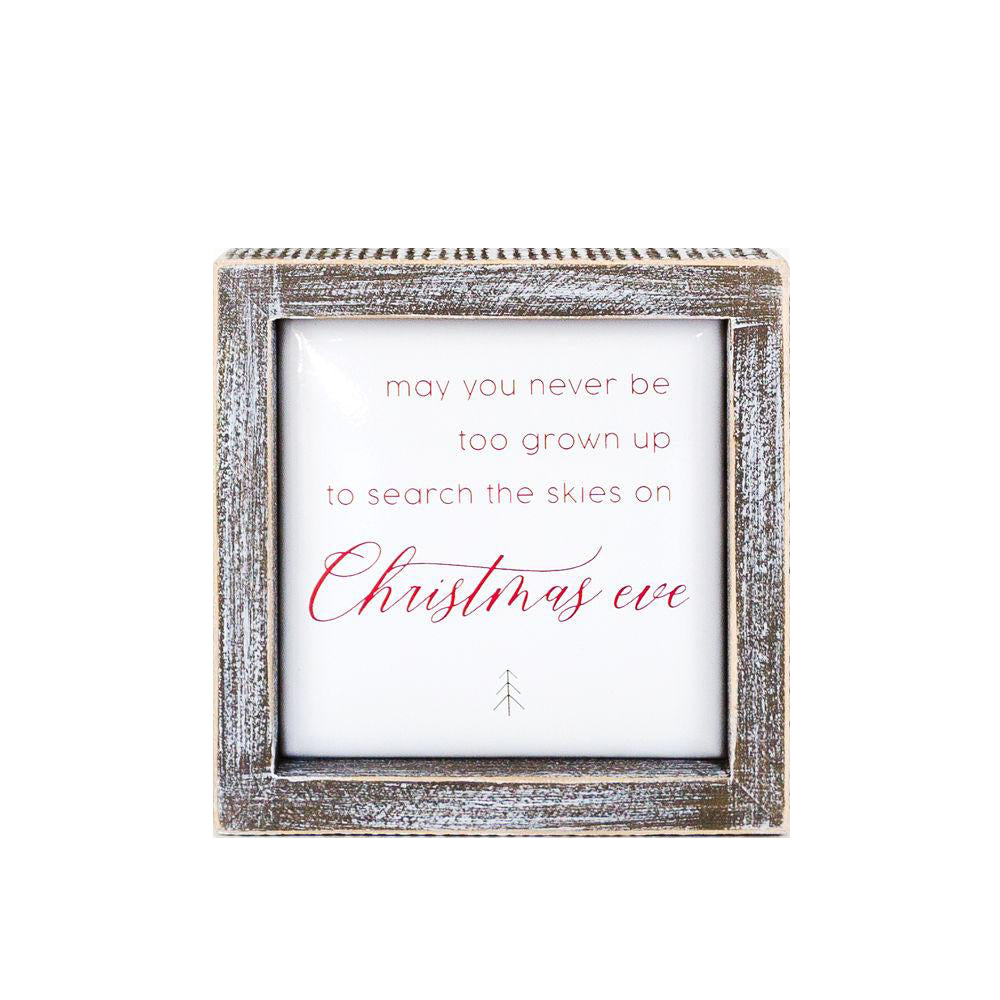 A beautifully crafted 5-inch wooden framed sign with metal embossed lettering that reads 'may you never be too grown to search the skies on Christmas eve'.