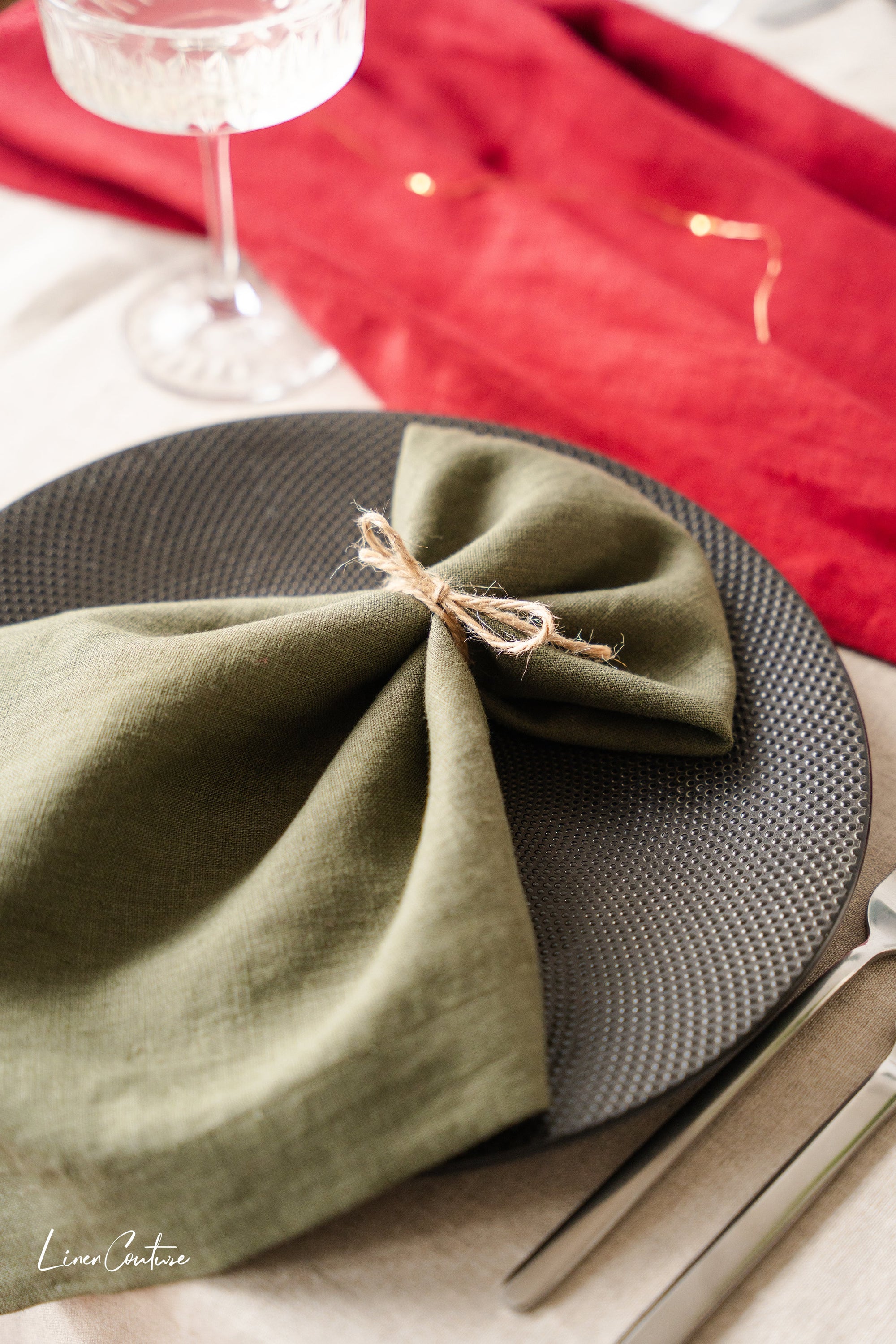 Set of two moss green linen dinner napkins with decorative hem, showcasing a soft and elegant texture, perfect for Christmas table settings.