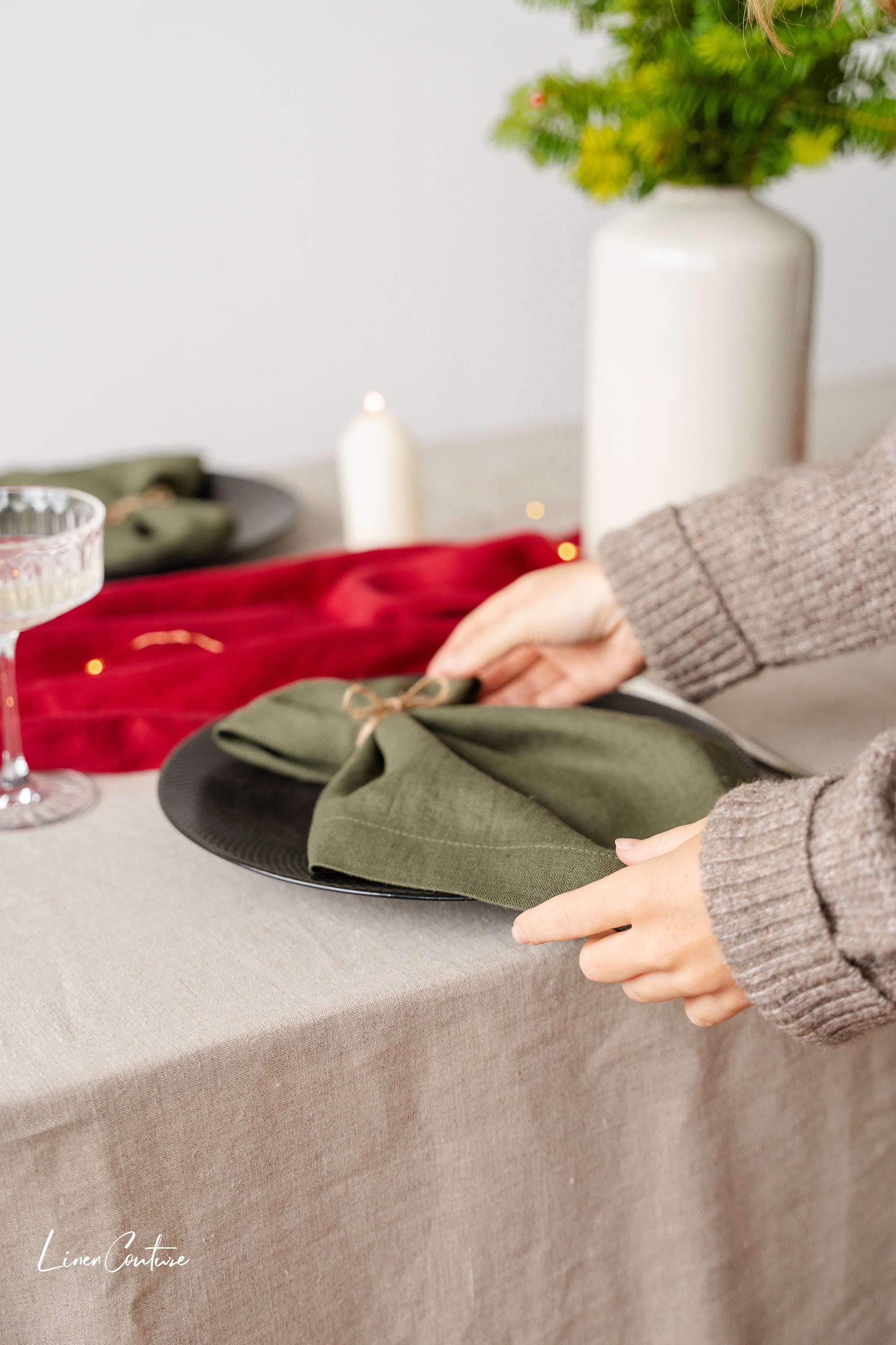 Set of two moss green linen dinner napkins with decorative hem, showcasing a soft and elegant texture, perfect for Christmas table settings.