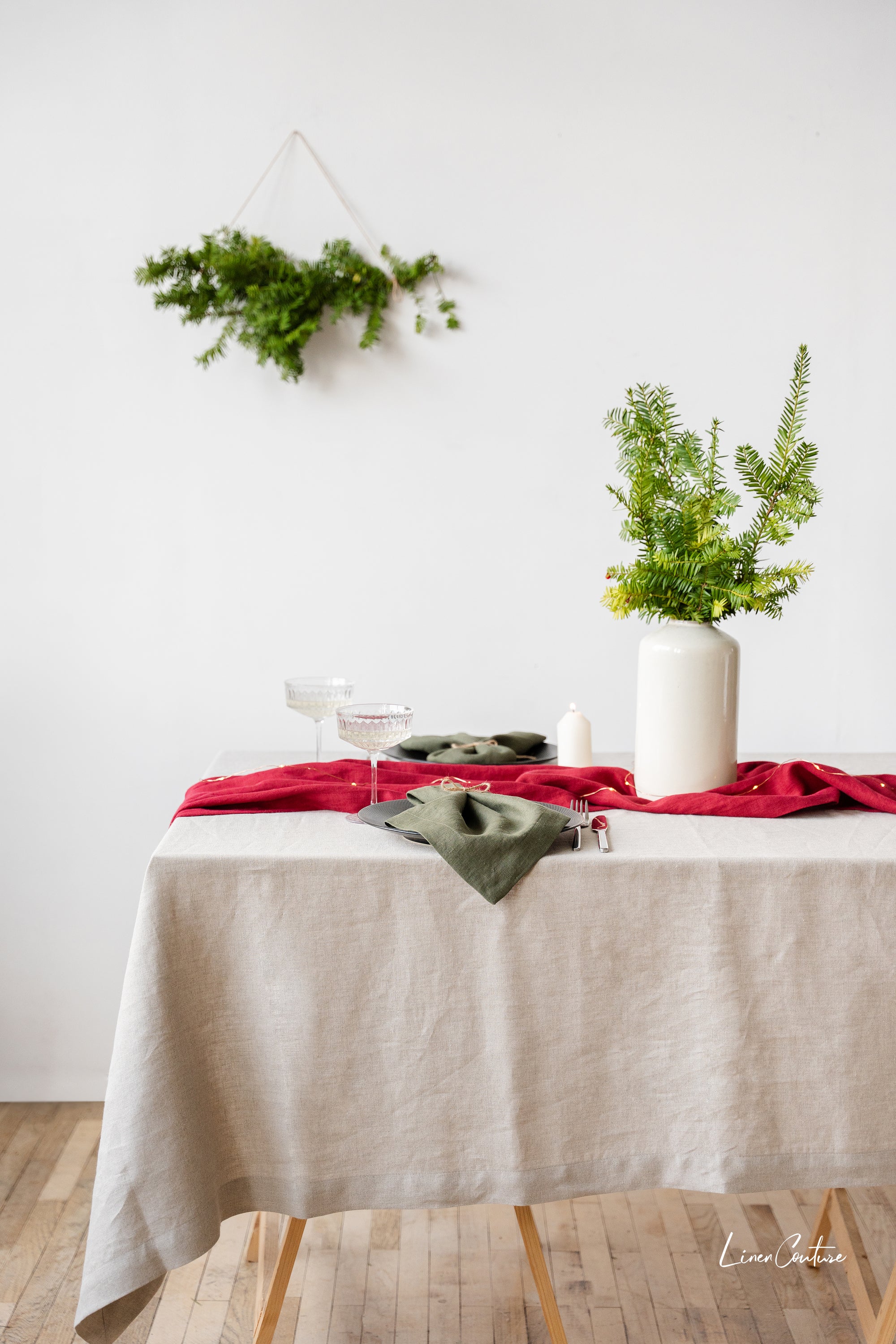 Set of two moss green linen dinner napkins with decorative hem, showcasing a soft and elegant texture, perfect for Christmas table settings.