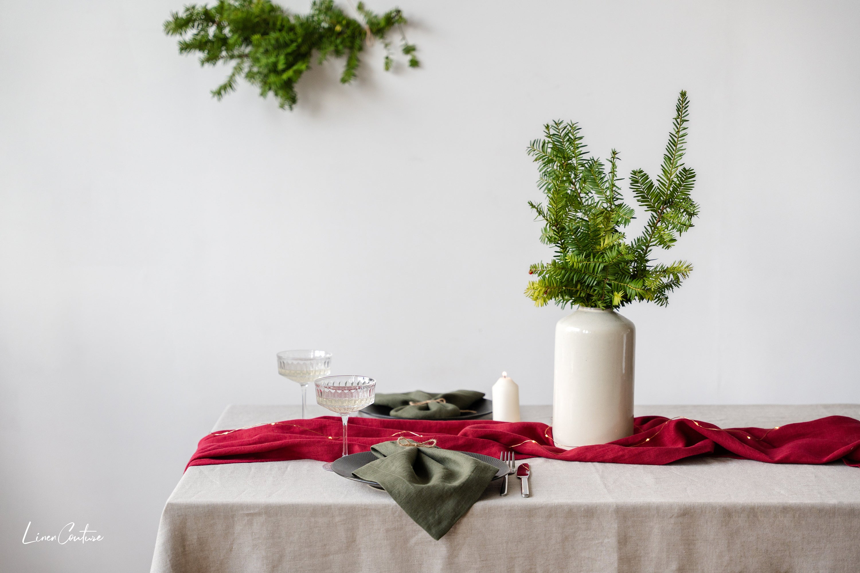 Set of two moss green linen dinner napkins with decorative hem, showcasing a soft and elegant texture, perfect for Christmas table settings.