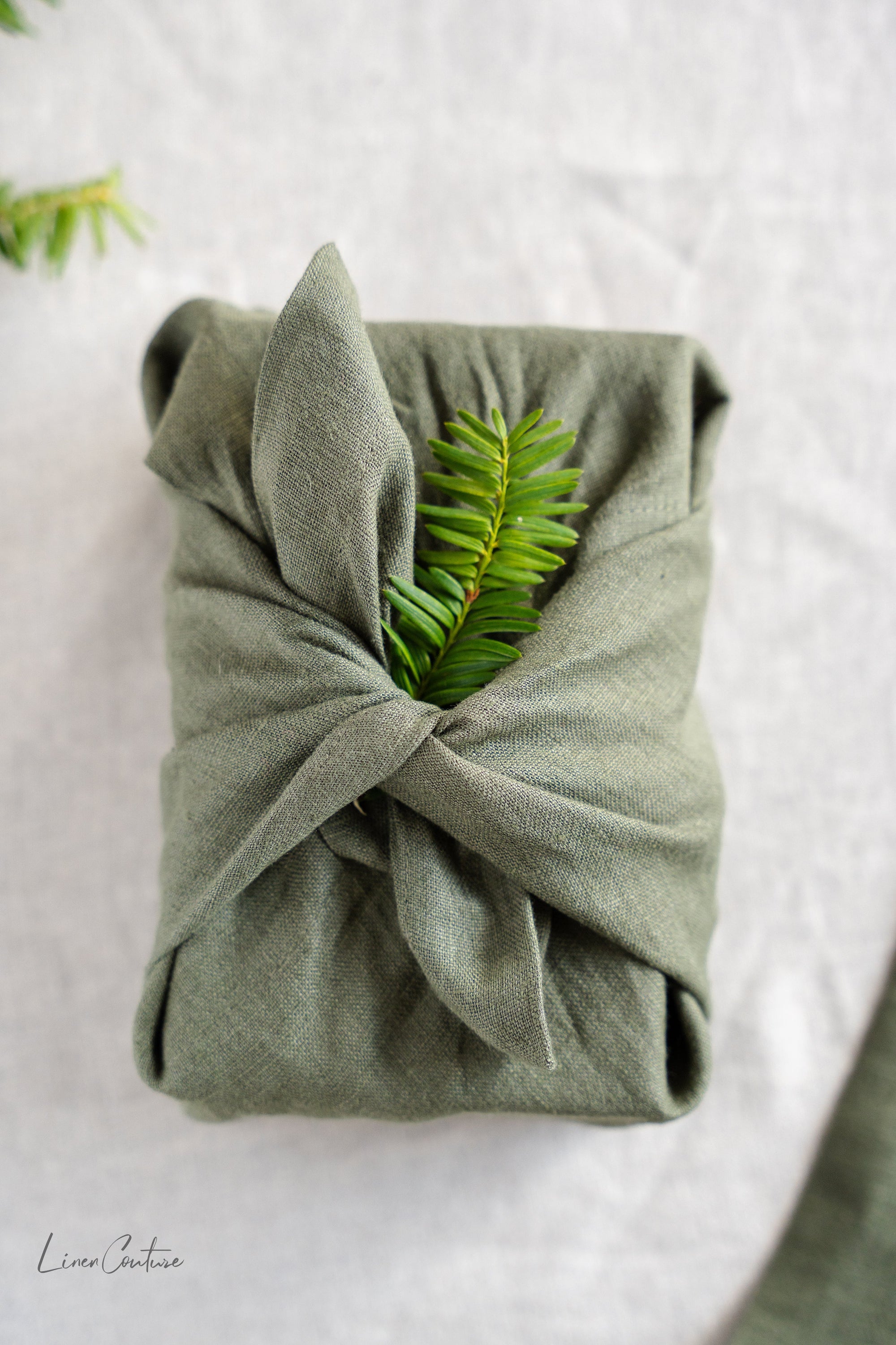 Set of two moss green linen dinner napkins with decorative hem, showcasing a soft and elegant texture, perfect for Christmas table settings.