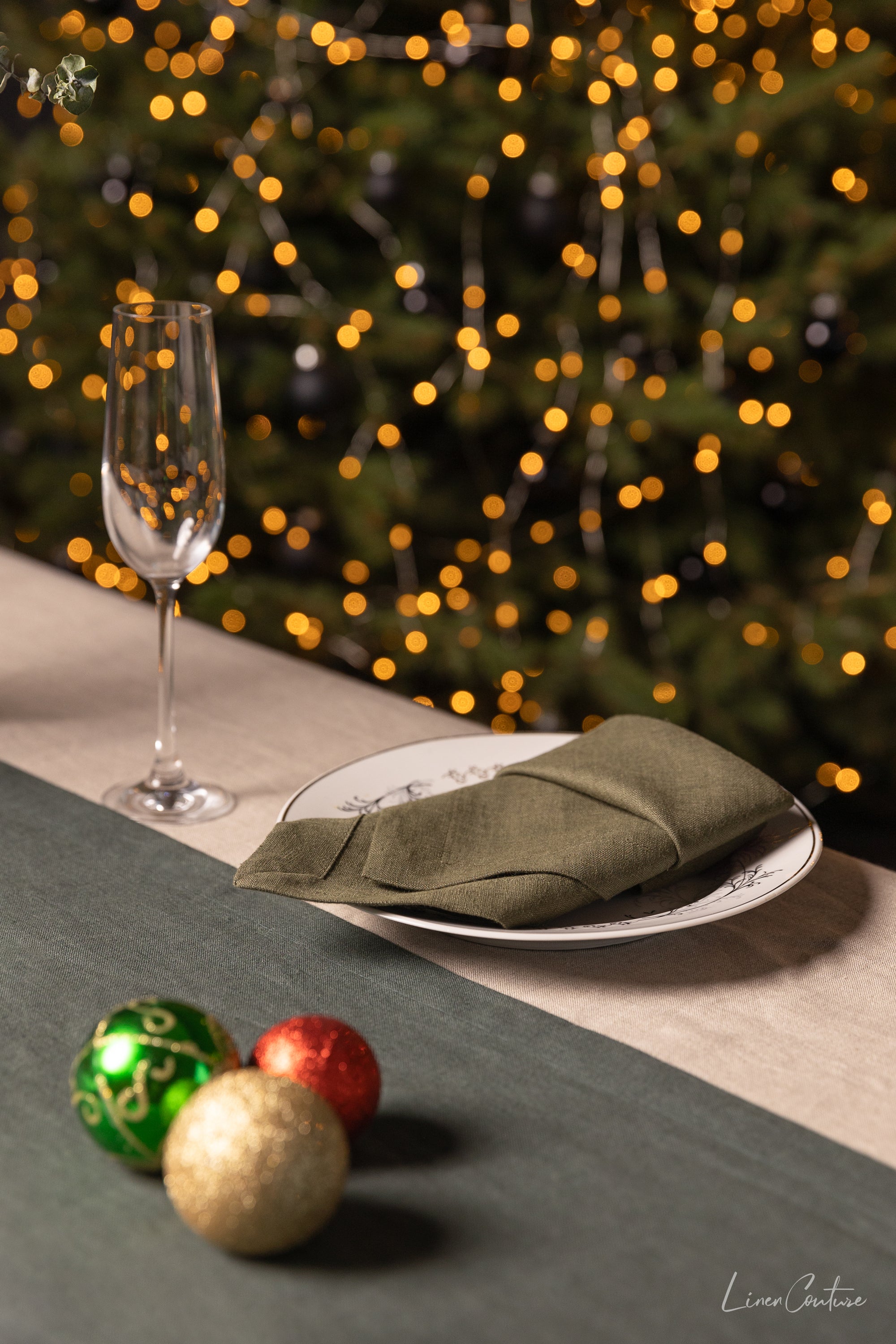 Set of two moss green linen dinner napkins with decorative hem, showcasing a soft and elegant texture, perfect for Christmas table settings.