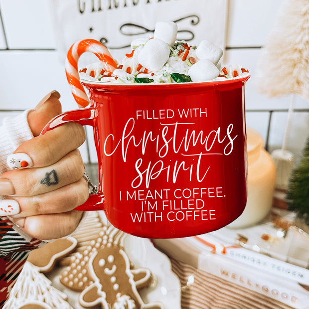 A festive Christmas Spirit Mug in red ceramic with white lettering, showcasing a cheerful design on both sides, perfect for holiday beverages.