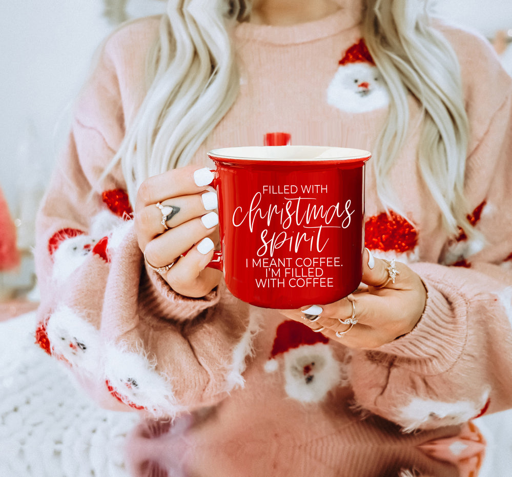 A festive Christmas Spirit Mug in red ceramic with white lettering, showcasing a cheerful design on both sides, perfect for holiday beverages.