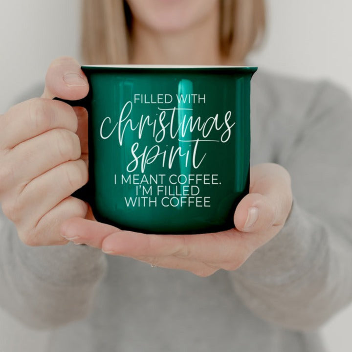 A festive Christmas Spirit Mug in red ceramic with white lettering, showcasing a cheerful design on both sides, perfect for holiday beverages.