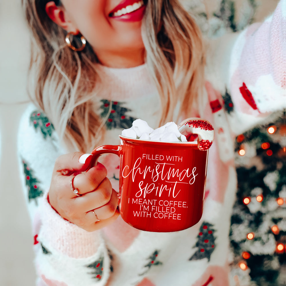 A festive Christmas Spirit Mug in red ceramic with white lettering, showcasing a cheerful design on both sides, perfect for holiday beverages.