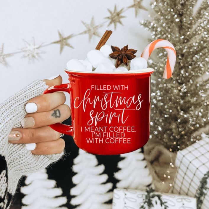 A festive Christmas Spirit Mug in red ceramic with white lettering, showcasing a cheerful design on both sides, perfect for holiday beverages.