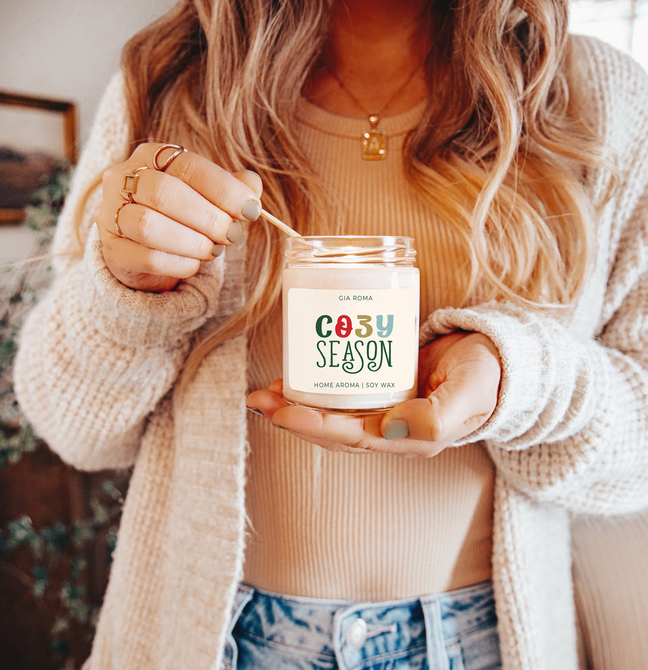 A beautifully crafted 9oz Cozy Season Candle with a warm glow, featuring a blend of winter scents like citrus, cloves, and pine cones.