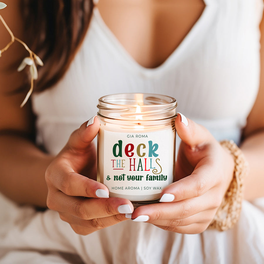 Deck The Halls Candle in a 9oz jar with festive scent notes of clove, cinnamon, berry, plum, and fir, perfect for holiday ambiance.