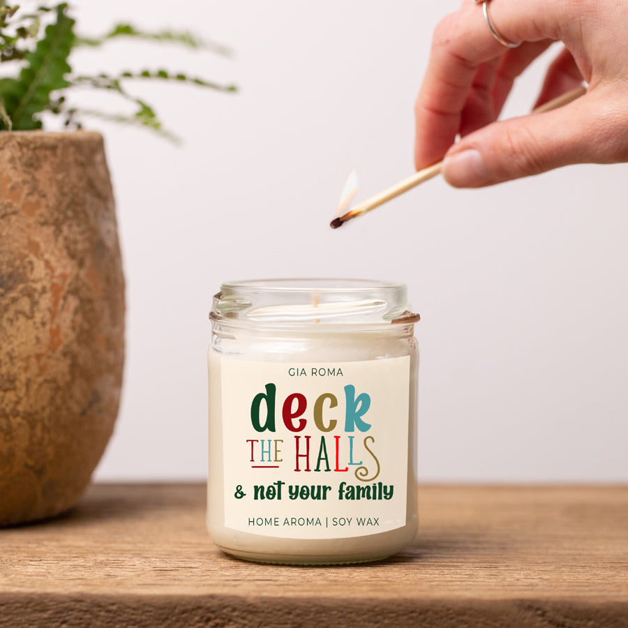 Deck The Halls Candle in a 9oz jar with festive scent notes of clove, cinnamon, berry, plum, and fir, perfect for holiday ambiance.