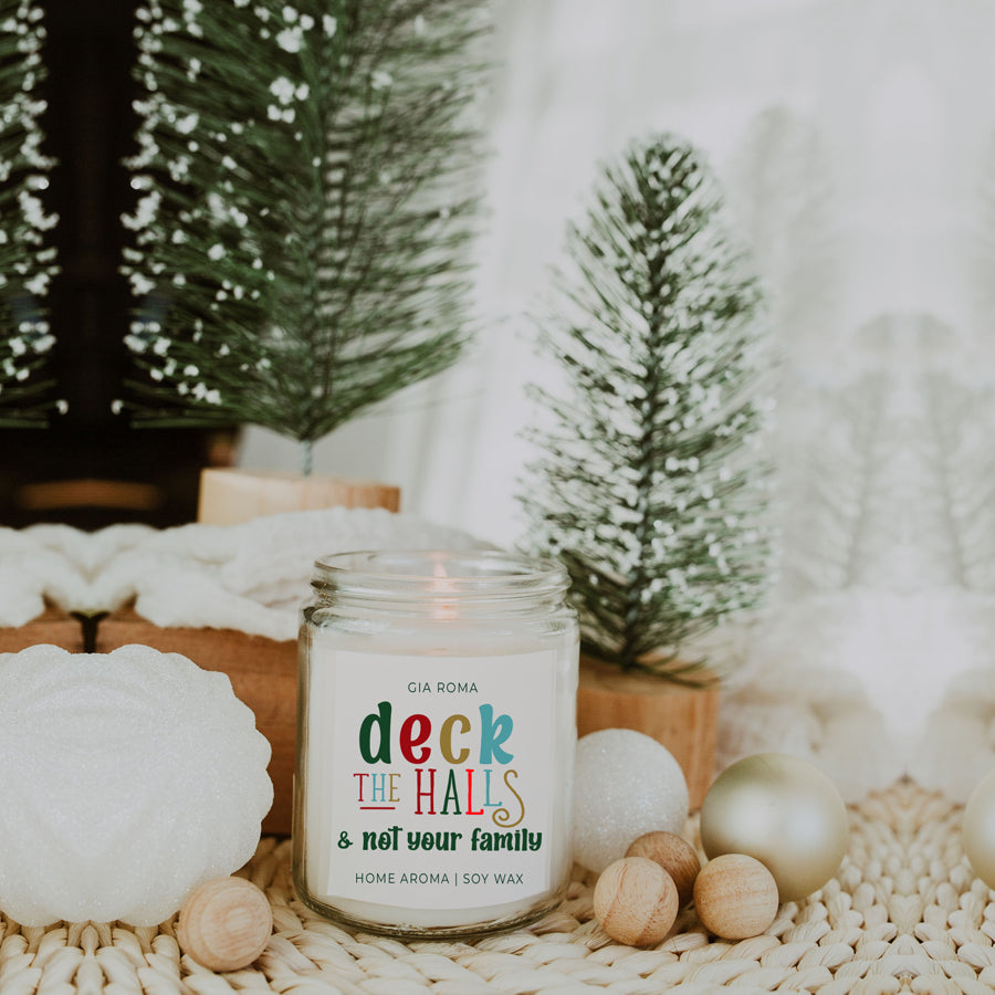 Deck The Halls Candle in a 9oz jar with festive scent notes of clove, cinnamon, berry, plum, and fir, perfect for holiday ambiance.