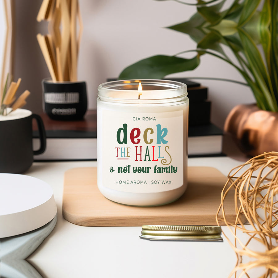 Deck The Halls Candle in a 9oz jar with festive scent notes of clove, cinnamon, berry, plum, and fir, perfect for holiday ambiance.