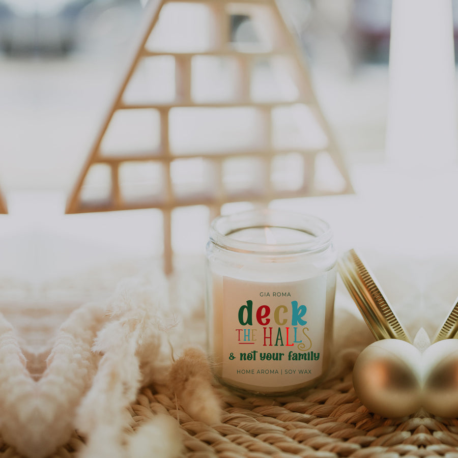 Deck The Halls Candle in a 9oz jar with festive scent notes of clove, cinnamon, berry, plum, and fir, perfect for holiday ambiance.