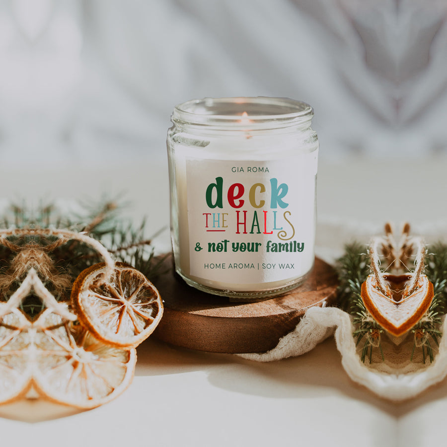 Deck The Halls Candle in a 9oz jar with festive scent notes of clove, cinnamon, berry, plum, and fir, perfect for holiday ambiance.