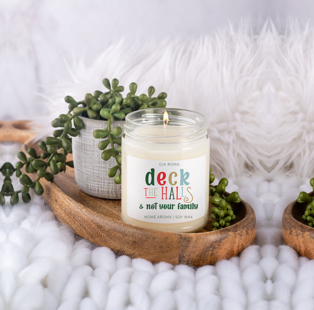 Deck The Halls Candle in a 9oz jar with festive scent notes of clove, cinnamon, berry, plum, and fir, perfect for holiday ambiance.