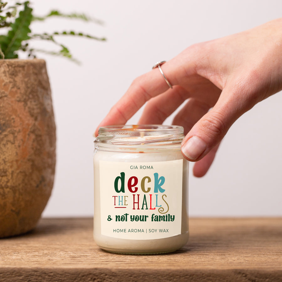 Deck The Halls Candle in a 9oz jar with festive scent notes of clove, cinnamon, berry, plum, and fir, perfect for holiday ambiance.