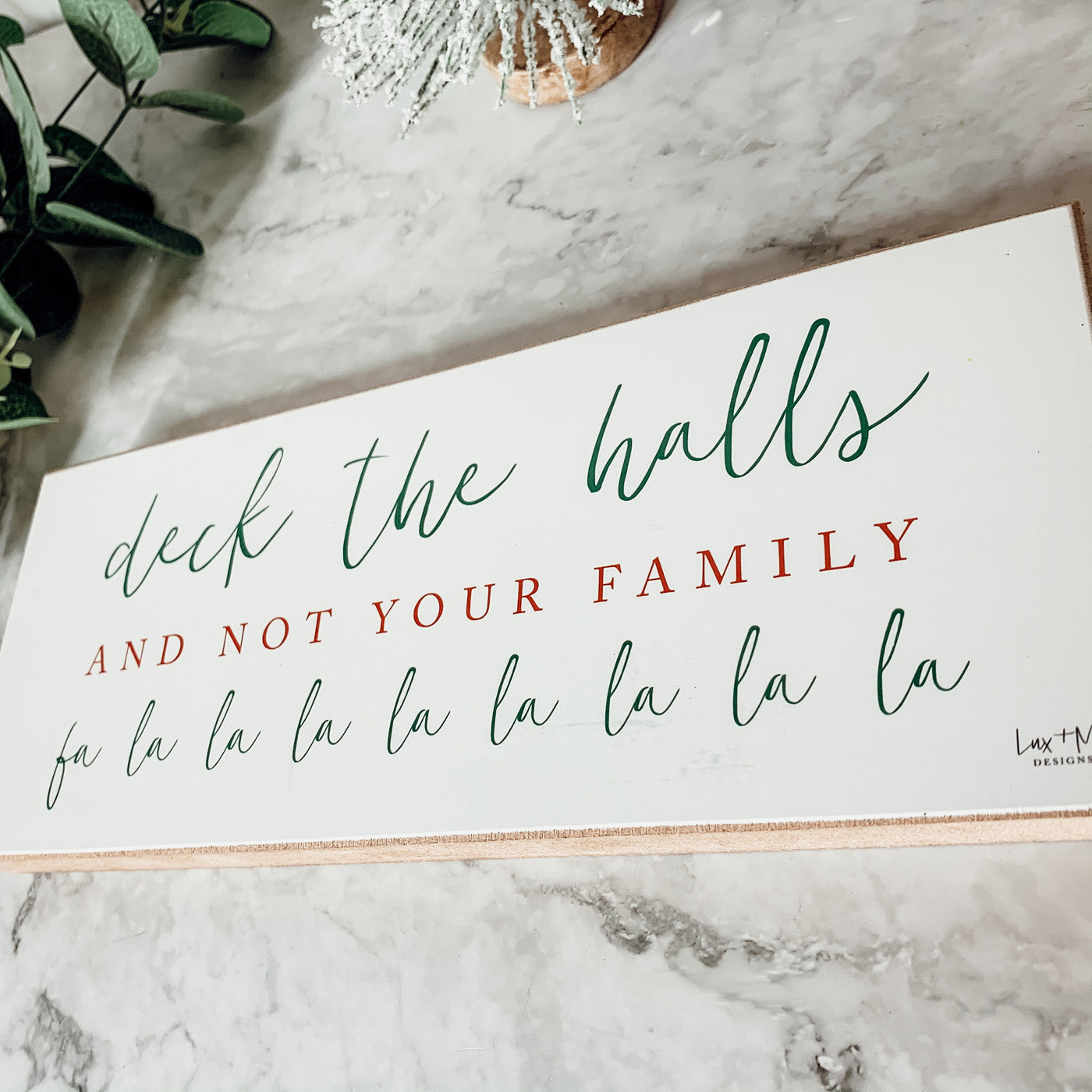 Handmade Deck The Halls Sign made of thick wood with a humorous Christmas quote in red and green, featuring a rustic textured area.