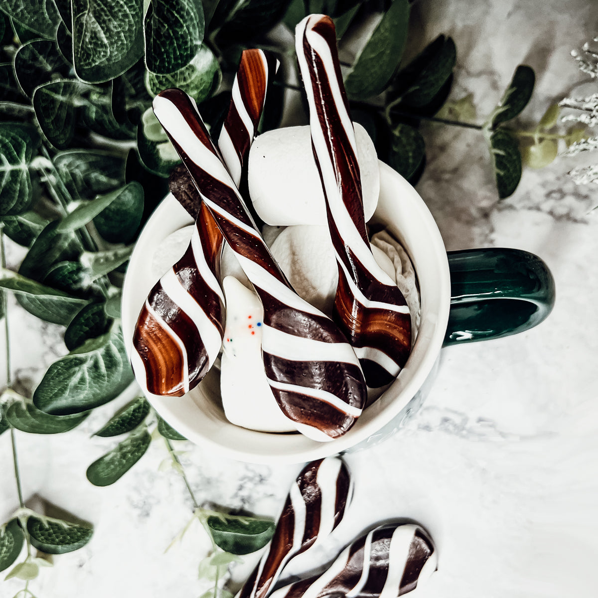 A colorful assortment of edible spoons in three flavors: Peppermint Twist, Cinnamon, and Hot Cocoa Twist, beautifully packaged in a gift box.