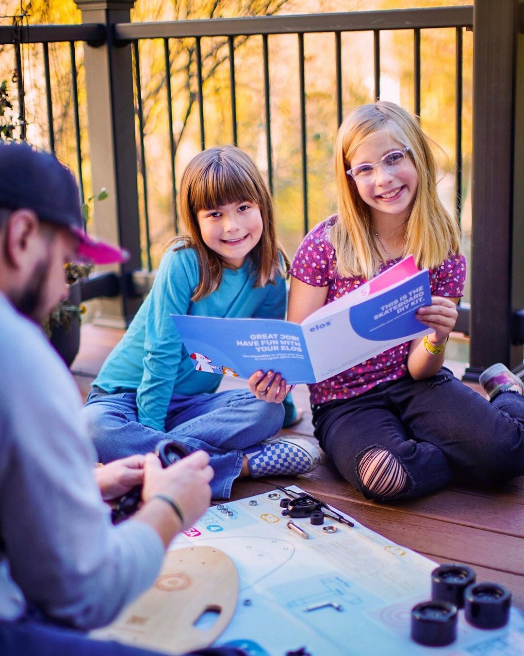 Elos Skateboards DIY Kit showcasing colorful skateboard parts and instruction booklet, perfect for family bonding and holiday fun.