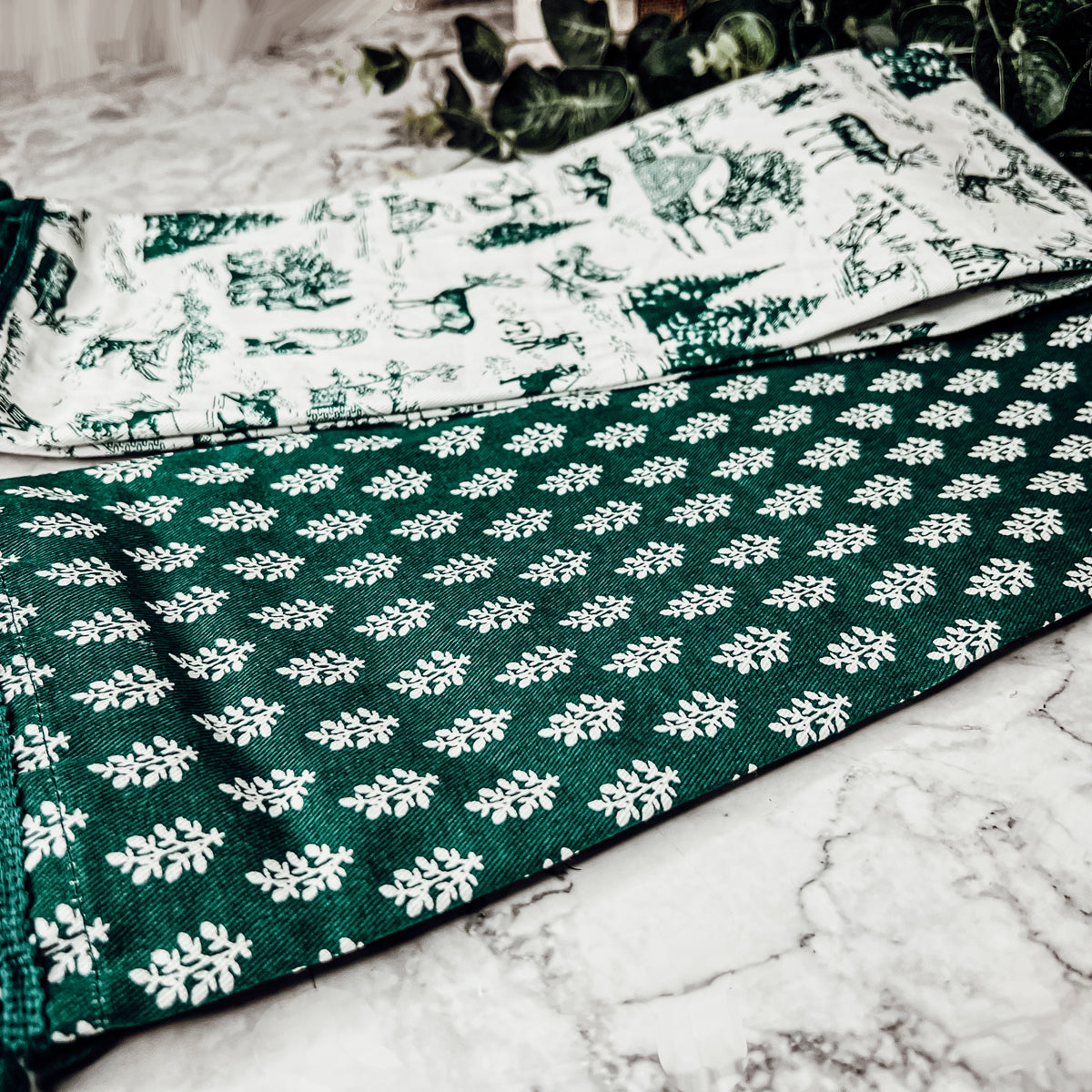 Set of two forest green dish towels with Christmas design, showcasing a classic forest pattern on durable cotton fabric.