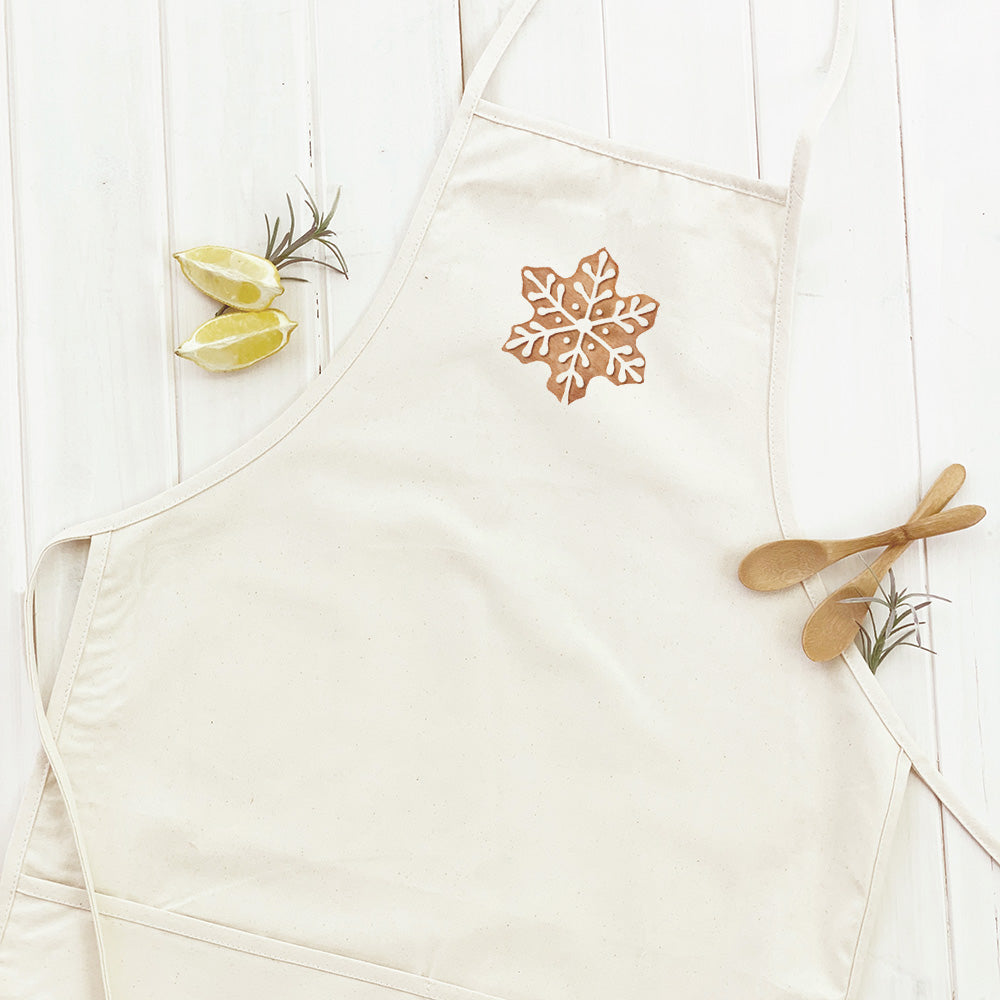 Gingerbread Cookies Women's Apron made of cotton canvas with twill ties and a divided front pocket, featuring a festive gingerbread design.