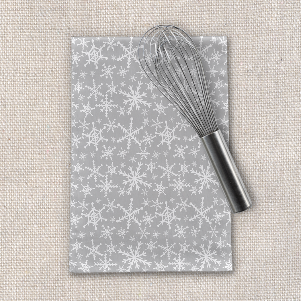 Gray Snowflakes Tea Towel featuring a cozy snowflake design on durable cotton twill fabric, perfect for kitchen use and decoration.