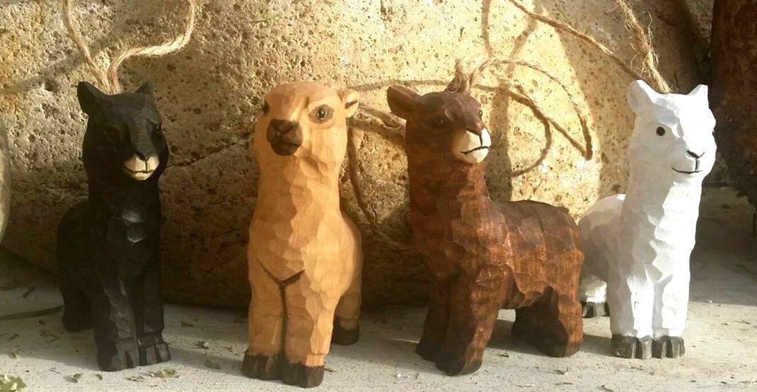 A set of hand-carved wooden alpaca ornaments made from basswood, featuring friendly smiling faces and textured fleecy coats, with jute hanging cords.