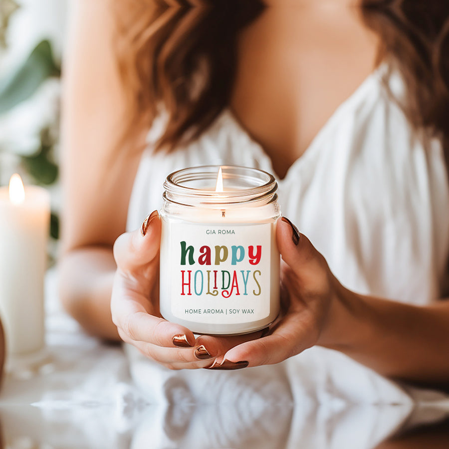 Happy Holiday Candle in a 9oz jar with festive scents of pine, orange, and woods, perfect for creating a cozy holiday atmosphere.