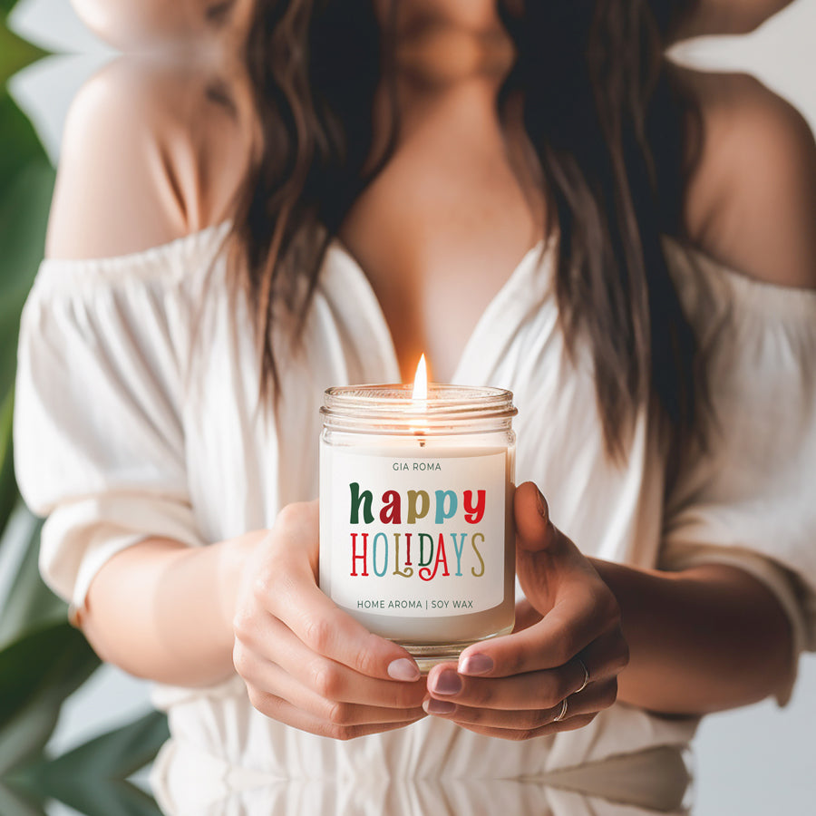 Happy Holiday Candle in a 9oz jar with festive scents of pine, orange, and woods, perfect for creating a cozy holiday atmosphere.