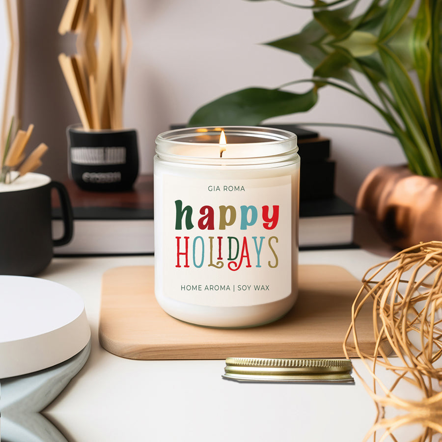 Happy Holiday Candle in a 9oz jar with festive scents of pine, orange, and woods, perfect for creating a cozy holiday atmosphere.