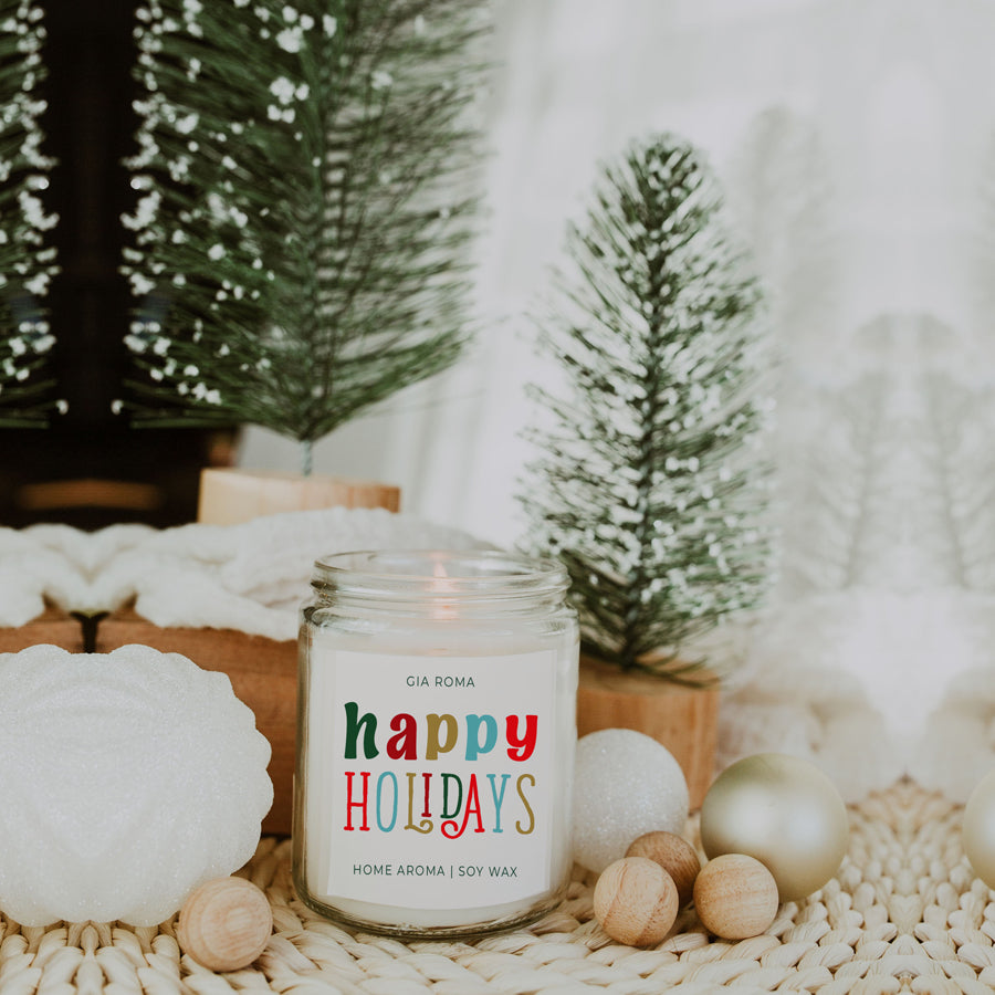 Happy Holiday Candle in a 9oz jar with festive scents of pine, orange, and woods, perfect for creating a cozy holiday atmosphere.