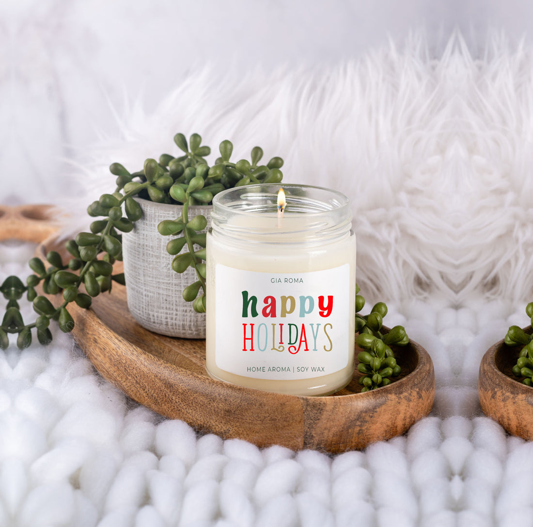 Happy Holiday Candle in a 9oz jar with festive scents of pine, orange, and woods, perfect for creating a cozy holiday atmosphere.