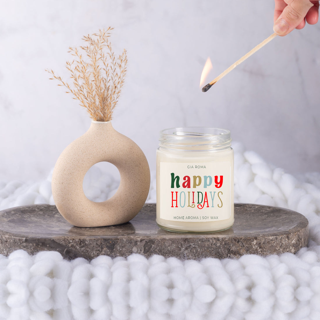 Happy Holiday Candle in a 9oz jar with festive scents of pine, orange, and woods, perfect for creating a cozy holiday atmosphere.