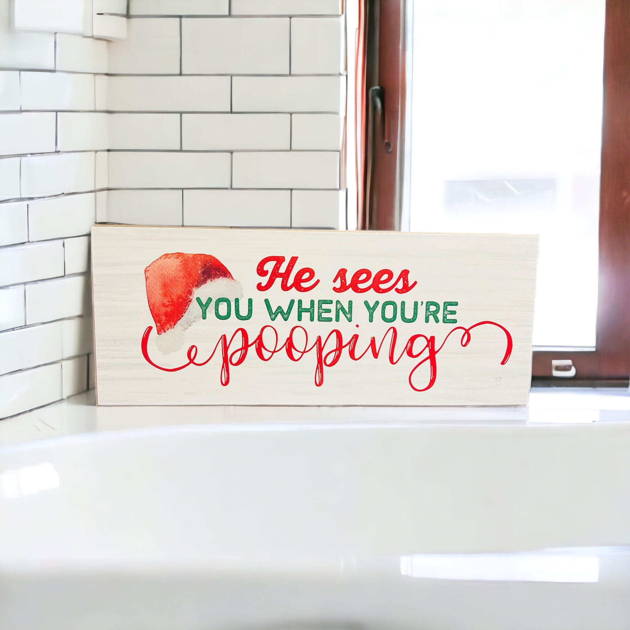 A whimsical wooden sign reading 'He sees you when you're pooping', perfect for Christmas decor, showcasing a humorous design.