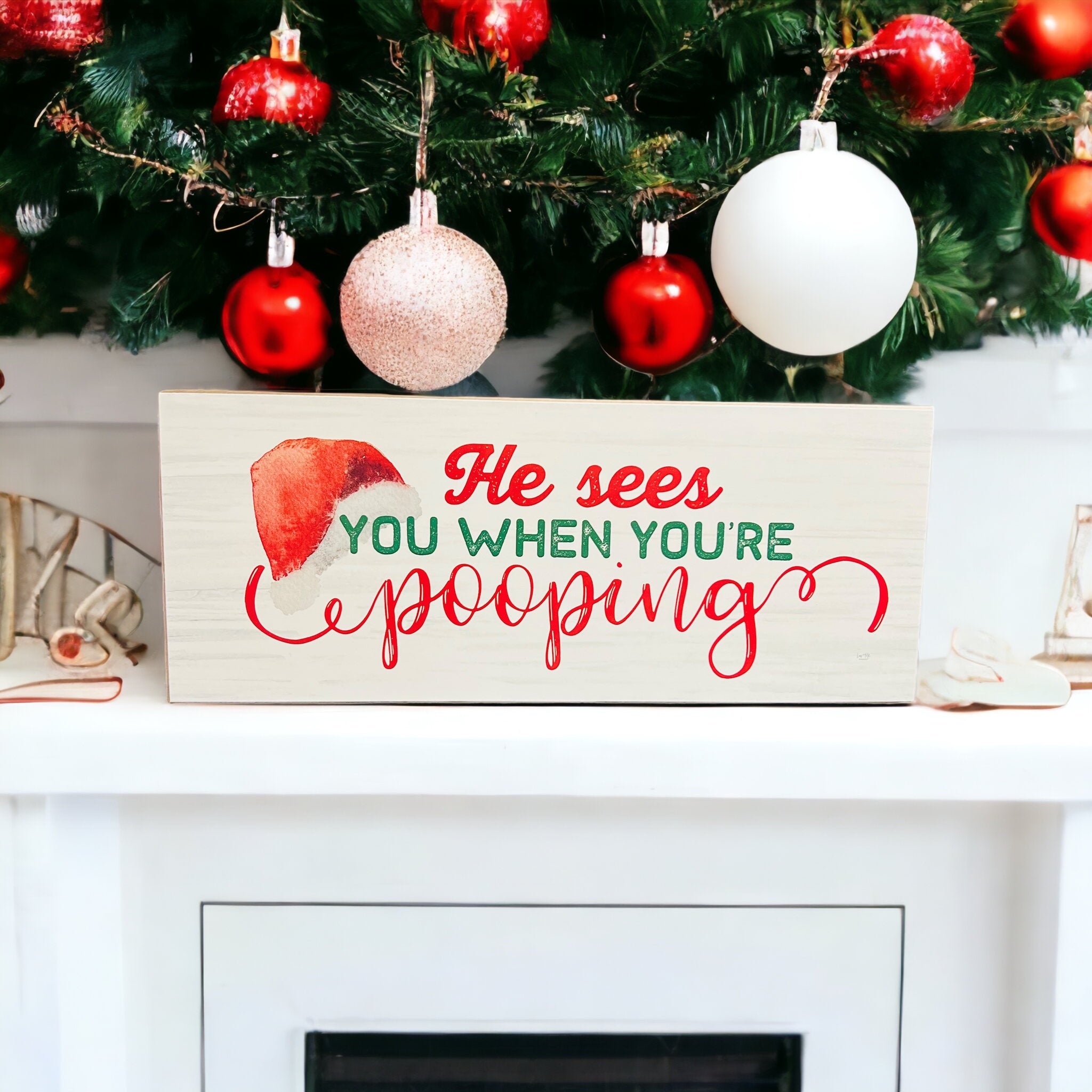 A whimsical wooden sign reading 'He sees you when you're pooping', perfect for Christmas decor, showcasing a humorous design.