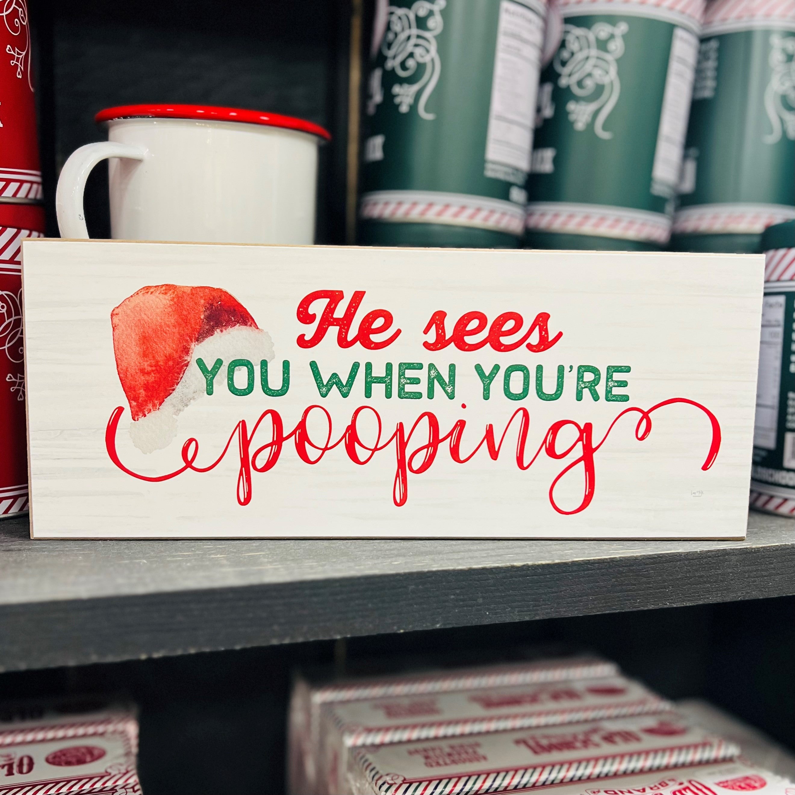 A whimsical wooden sign reading 'He sees you when you're pooping', perfect for Christmas decor, showcasing a humorous design.