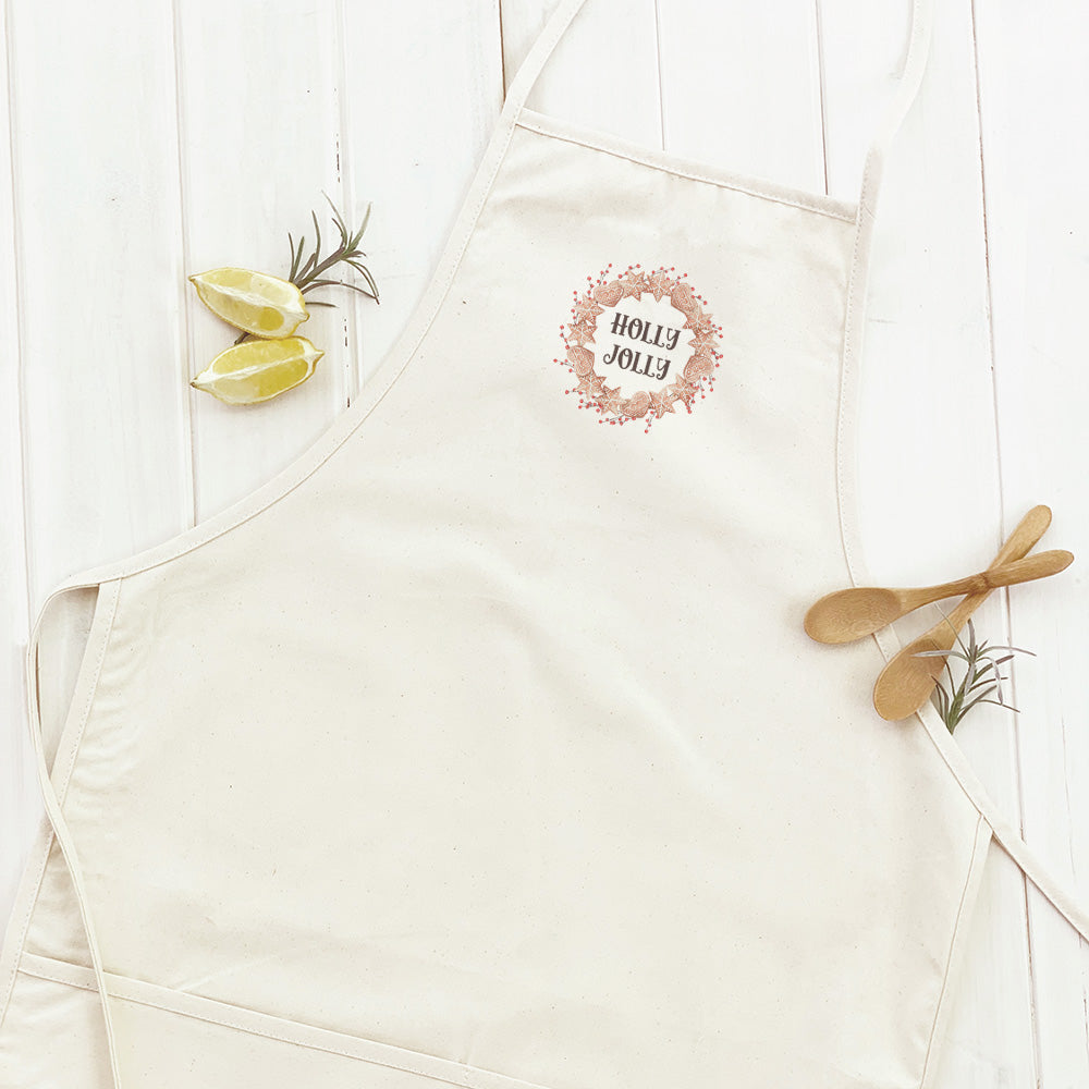 A festive women's apron featuring a gingerbread wreath design, made from durable cotton canvas with natural twill ties.