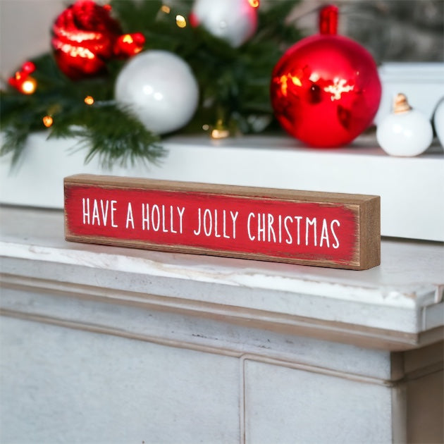 Holly Jolly Sitter Sign, a wooden block sign with festive lettering, perfect for holiday decor.