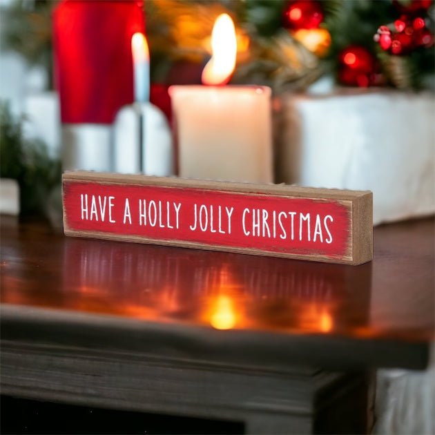 Holly Jolly Sitter Sign, a wooden block sign with festive lettering, perfect for holiday decor.