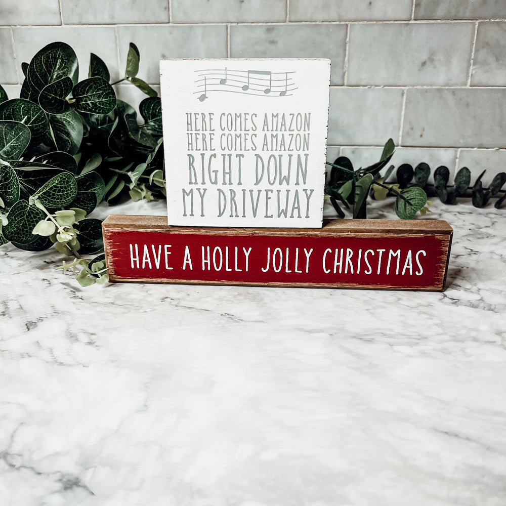 Holly Jolly Sitter Sign, a wooden block sign with festive lettering, perfect for holiday decor.