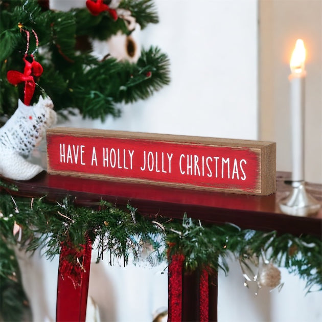 Holly Jolly Sitter Sign, a wooden block sign with festive lettering, perfect for holiday decor.